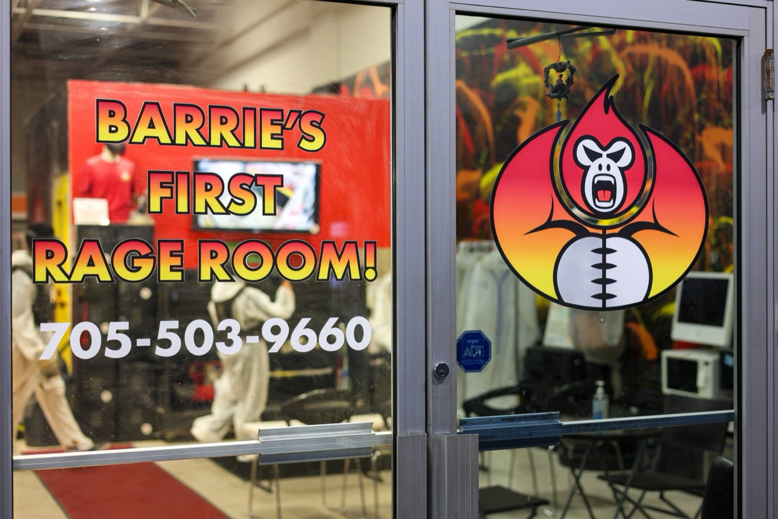 Glass entrance doors reading Barrie's First Rage Room with the Break N Rage flame logo