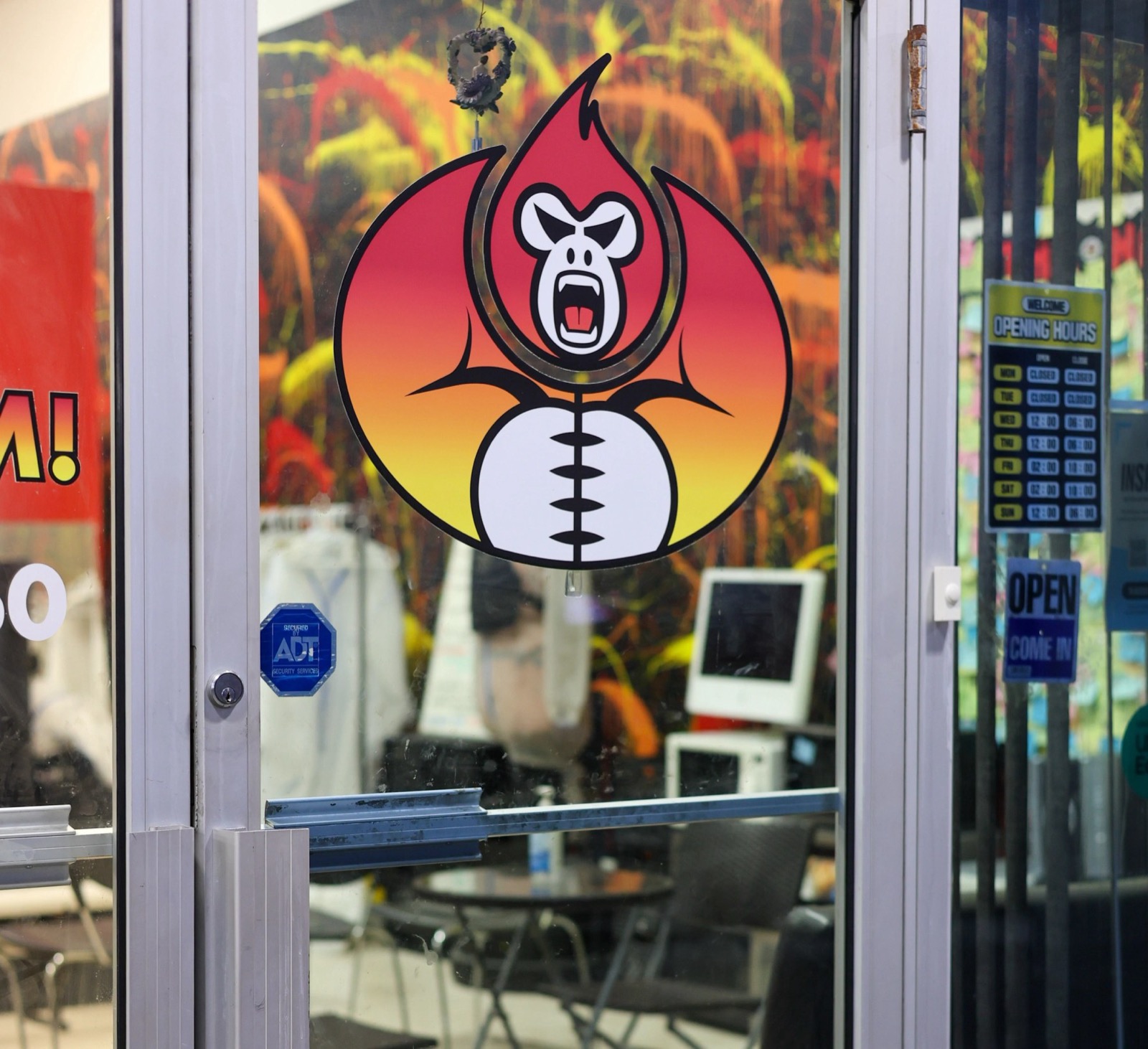 The Break N Rage logo — a roaring ape inside a flame — on the glass entrance door beside the opening hours