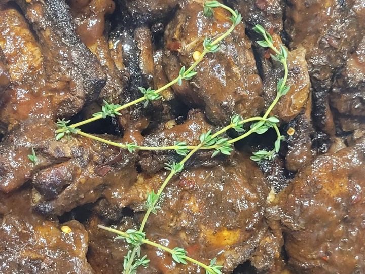 Jerk chicken pieces in dark spiced sauce, finished with fresh thyme